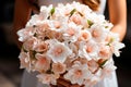 Bouquet for a wedding of delicate peach flowers in the hands of the bride