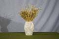 bouquet of wheat spikes in a paper vase. handmade still life. Royalty Free Stock Photo