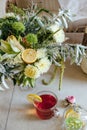 A bouquet of white asters, green lilies and other flowers, decorated with lemons, a cup of tea with a slice of lemon on the table Royalty Free Stock Photo
