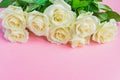 Bouquet of white blooming roses  on pastel pink background. Romantic floral frame. Copy space Royalty Free Stock Photo