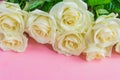 Bouquet of white blooming roses  on pastel pink background. Romantic floral frame. Copy space Royalty Free Stock Photo