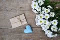 Bouquet of white chrysanthemums with envelope and blue heart on wood Royalty Free Stock Photo