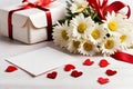 A bouquet of white daisies and a gift box on a table with red satin ribbons, a sheet of notes and red hearts on a Royalty Free Stock Photo