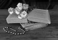 Bouquet of white flowers lying on two ancient books lying on a t Royalty Free Stock Photo