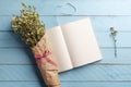 Flower bouquet and open notebook on a blue table Royalty Free Stock Photo