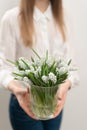 Bouquet of white muscari flowers in glass vase in woman hands. Spring bulbous flowers. Flower shop concept Royalty Free Stock Photo