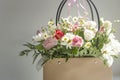 A bouquet of white and pink summer flowers isolated on a grey background. Light falls from the side.