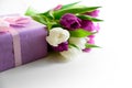 Bouquet of white and purple tulips, gift box and blank paper on white wooden background. Top view. Flat lay. Copy space Royalty Free Stock Photo