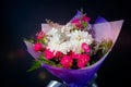 Bouquet of white and red flowers in purple paper on black background Royalty Free Stock Photo