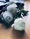 Bouquet of white roses in bag on wooden table. Royalty Free Stock Photo