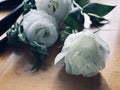 Bouquet of white roses in bag on wooden table. Royalty Free Stock Photo