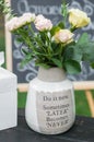 Bouquet of white roses in a ceramic vase. The vase has message \