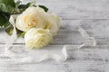 Bouquet of white roses decorated with ribbon on white wooden background Royalty Free Stock Photo