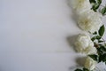 Bouquet of white roses framework on white wooden background. Floral mock-up. Top view. Copy space. Wedding card