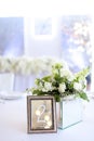 Bouquet of white roses near frame with number two on banquet table. Royalty Free Stock Photo