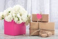 A bouquet of white roses in a pink box and a gift box with a heart symbol for inscription. Royalty Free Stock Photo