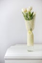 Bouquet of white tulips on an antique white furniture