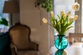 A bouquet of white tulips in a blue green glass vase in bright morning sun. Modern interior design, fresh spring flowers concept Royalty Free Stock Photo