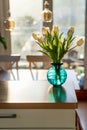 A bouquet of white tulips in a blue green glass vase in bright morning sun. Modern interior design, fresh spring flowers Royalty Free Stock Photo