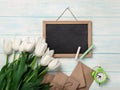 A bouquet of white tulips with chalk board and envelopes on blue wooden boards