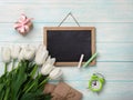 A bouquet of white tulips with chalk board, gift box envelopes on blue wooden boards