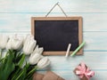 A bouquet of white tulips with chalk board, gift box envelopes on blue wooden boards