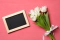 Bouquet of white tulips and photo frame with copy space for congratulation text on pink wooden background, banner mockup for Woman Royalty Free Stock Photo
