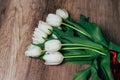 Many white tulips on wooden background, with red ribbon Royalty Free Stock Photo