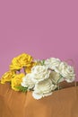 Bouquet of white and yellow roses in a brown paper bag on a pink background. Valentine's Day concept Royalty Free Stock Photo