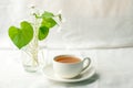 Bouquet of whitebells flower in a glass vase and cup of herbal tea. Snowdrop violet still life. Floral decoration. Spring and summ Royalty Free Stock Photo