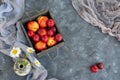 Bouquet of wild flowers chamomile with fruits of nectarines and plums in the wooden box Royalty Free Stock Photo