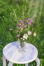 Bouquet of wild flowers in a glass vase on a rough wooden white bench, summer concept, farm rustic concept Royalty Free Stock Photo