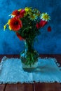 Bouquet of wild natural flowers in transparent glass vase on wooden table Royalty Free Stock Photo