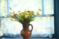 A bouquet of wildflowers in a clay jug on the veranda window. Retro vintage photos. Delicate soft selective focus. Royalty Free Stock Photo