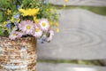 a bouquet of wildflowers of forget-me-nots, daisies and yellow dandelions in full bloom in a rusty rustic jar against a background Royalty Free Stock Photo