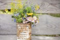 A bouquet of wildflowers of forget-me-nots, daisies and yellow dandelions in full bloom in a rusty rustic jar against a background Royalty Free Stock Photo