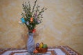 a glass vase with willow branches and a small basket of Easter eggs on a table, a bouquet of willow in a vase and a basket of Royalty Free Stock Photo