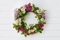 Bouquet wreath of lilac flowers on white wooden background. Royalty Free Stock Photo