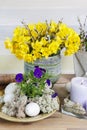 Bouquet of yellow daffodils and floral arrangement with pansy flowers, moss and eggs Royalty Free Stock Photo