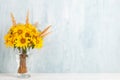 A bouquet of yellow flowers, sunflowers, in a glass vase on a blue background. Copy space Royalty Free Stock Photo
