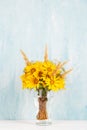 A bouquet of yellow flowers, sunflowers, in a glass vase on a blue background. Copy space Royalty Free Stock Photo