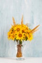 A bouquet of yellow flowers, sunflowers, in a glass vase on a blue background. Copy space Royalty Free Stock Photo