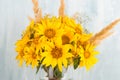 A bouquet of yellow flowers, sunflowers, in a glass vase on a blue background. Copy space Royalty Free Stock Photo