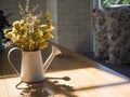 Bouquet of yellow flowers in watering can on wooden table Royalty Free Stock Photo