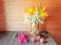 Bouquet of yellow lilies and white astilbe in clay vase, glasses of white wine, pink astilbe and fresh fruits near Royalty Free Stock Photo