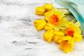 Bouquet of yellow narcissus and tulips on white wooden background Royalty Free Stock Photo