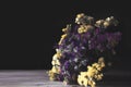 Bouquet of yellow and purple  flowers on a dark background. Bouquet of statice sea lavender Royalty Free Stock Photo