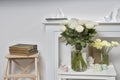 Bouquet of yellow ranunculus and white rose in a glass vase on the white table