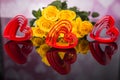 A bouquet of yellow roses and red plastic hearts. Valentine`s Day Royalty Free Stock Photo