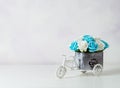 A bouquet of yellow roses in a wooden small decorative box in the form of a bicycle on a light background. Vintage Royalty Free Stock Photo